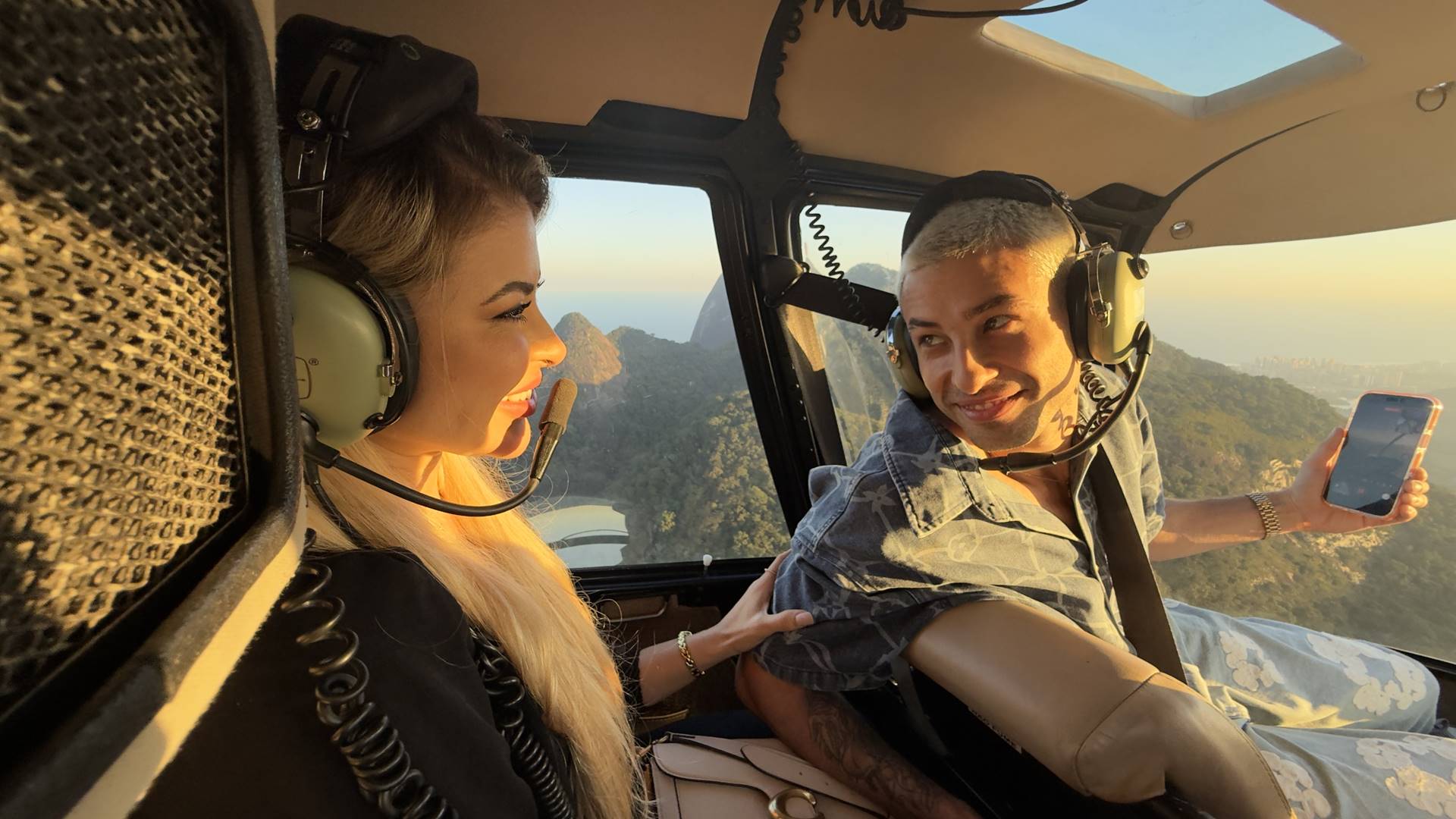Casal vivendo momento especial em voo de helicóptero com a Rio Blusky com vista panorâmica no Rio de Janeiro