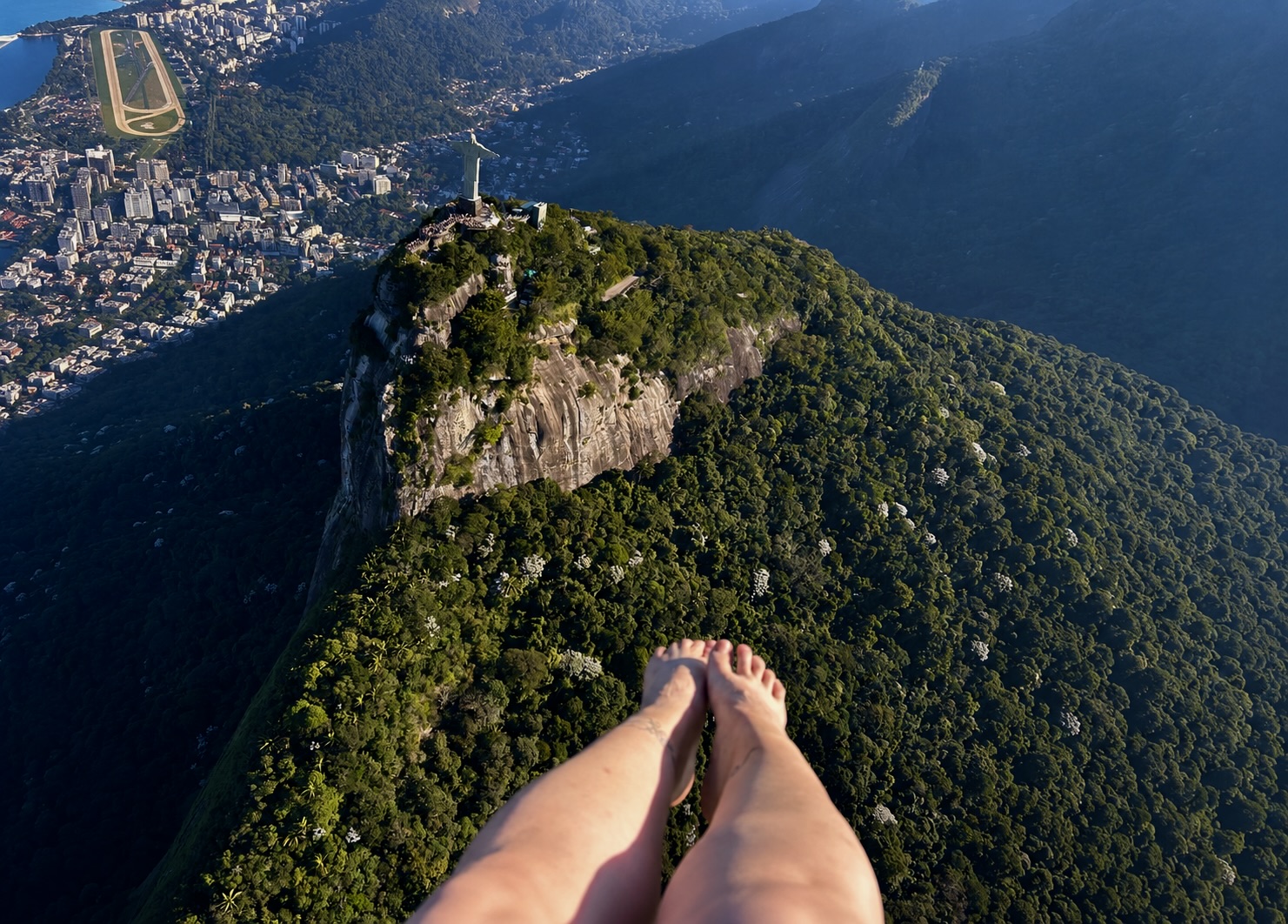Mulher com as pernas para fora de helicóptero em passeio panorâmico no Rio de Janeiro pela Rio Bluesky